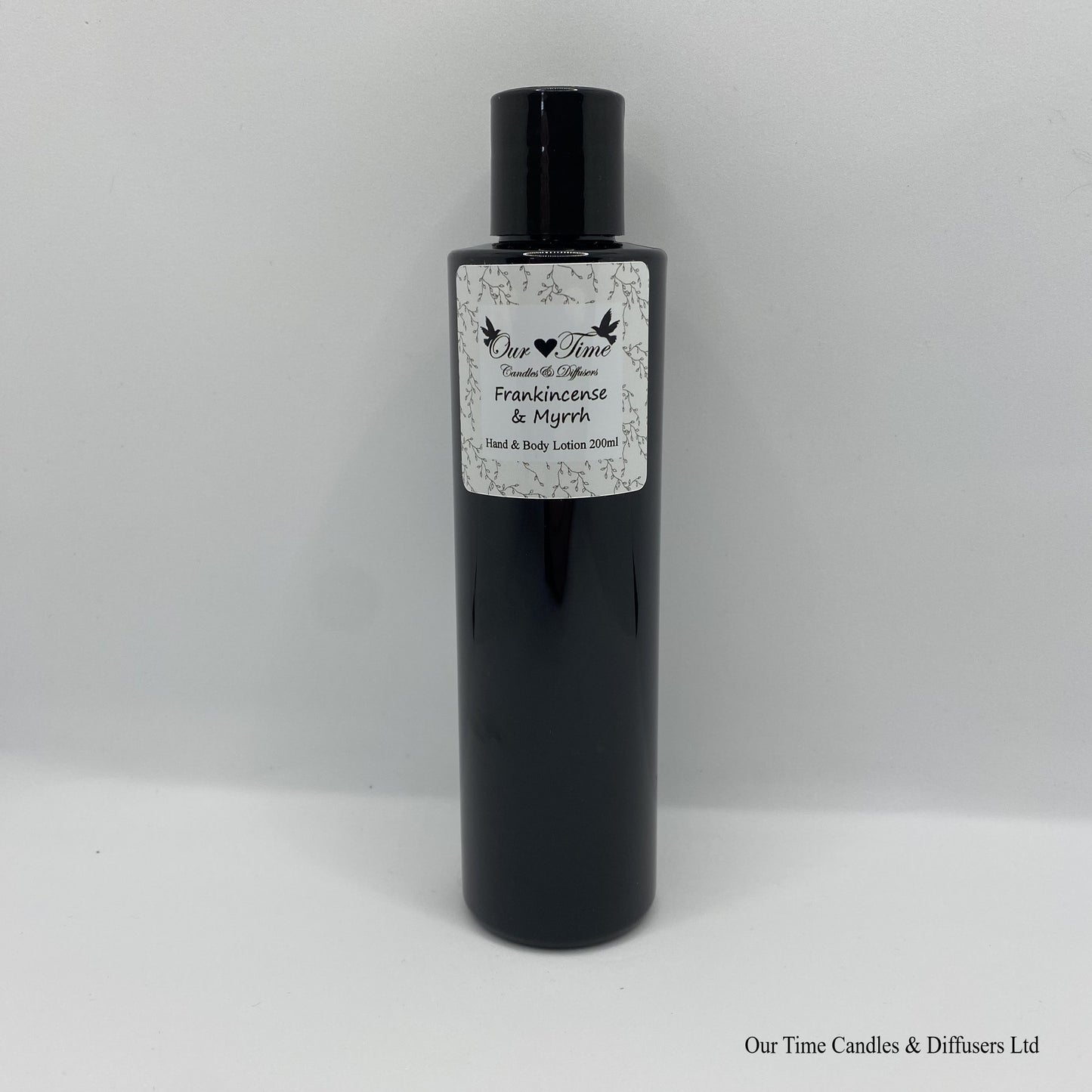 Black Bottle with black cap and white label with hand and body lotion