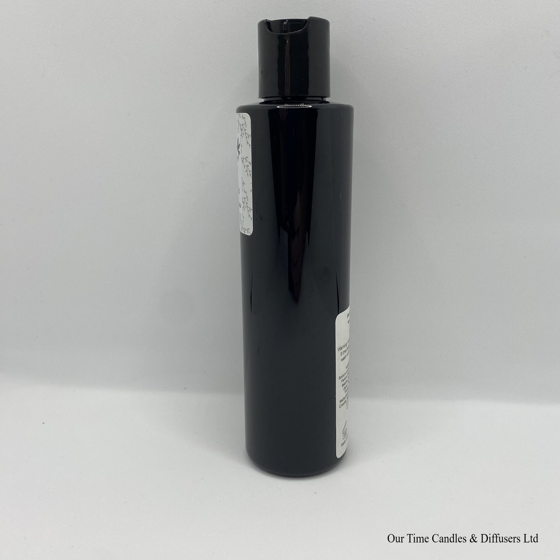 Black Bottle with black cap and white label with hand and body wash