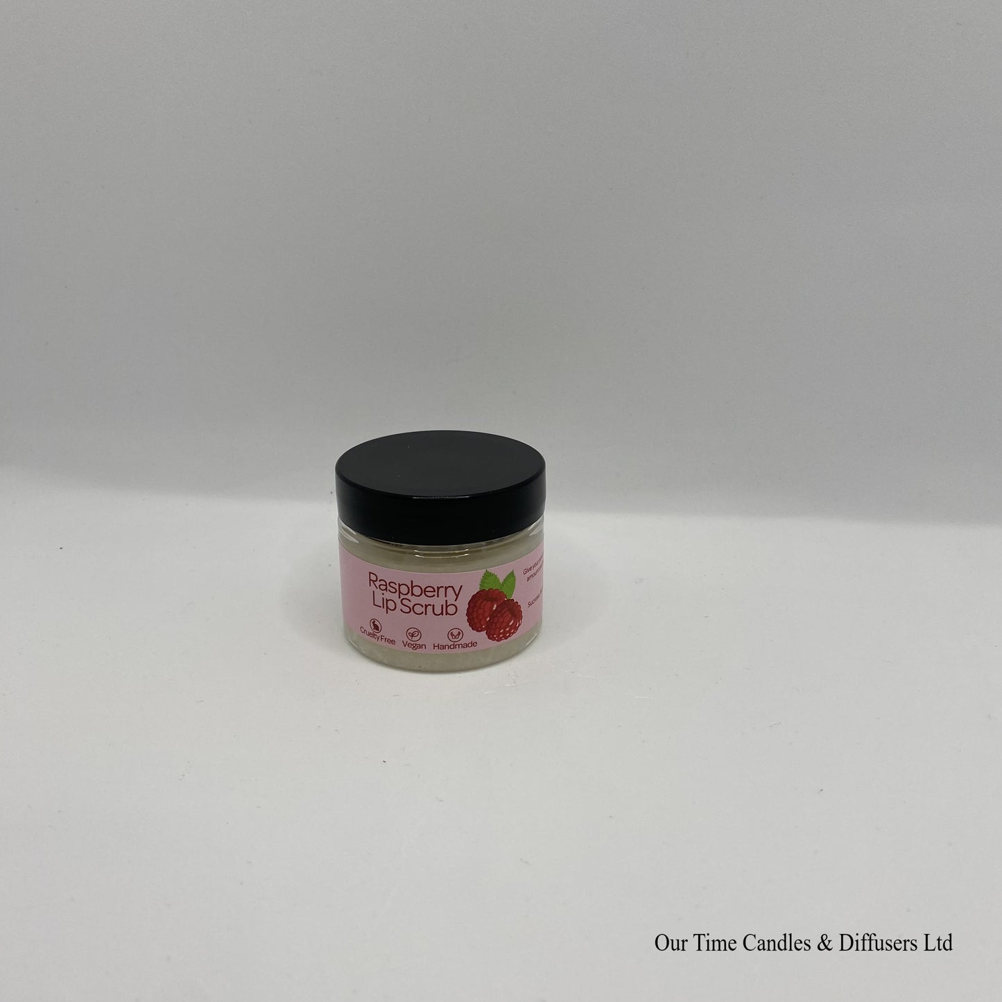 Small clear jar containing lip scrub with black lid