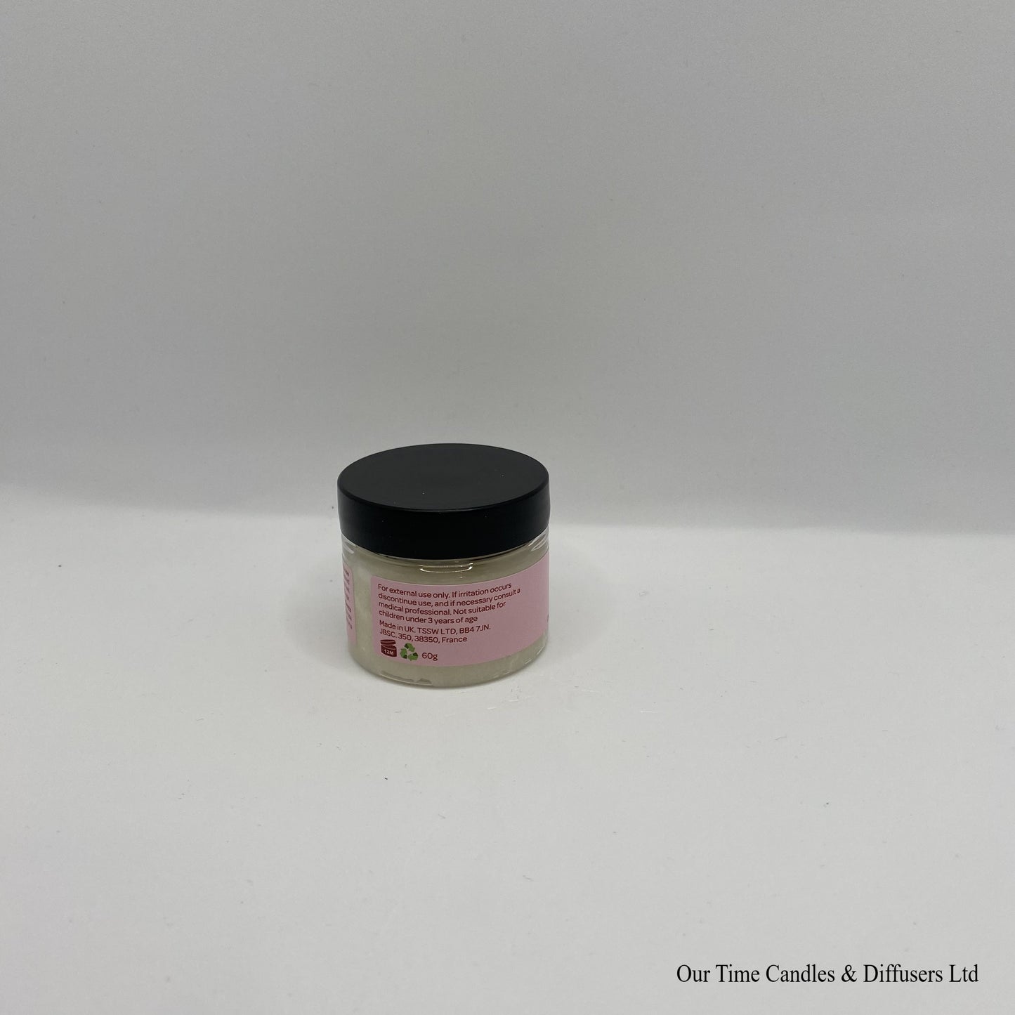 Small clear jar containing lip scrub with black lid