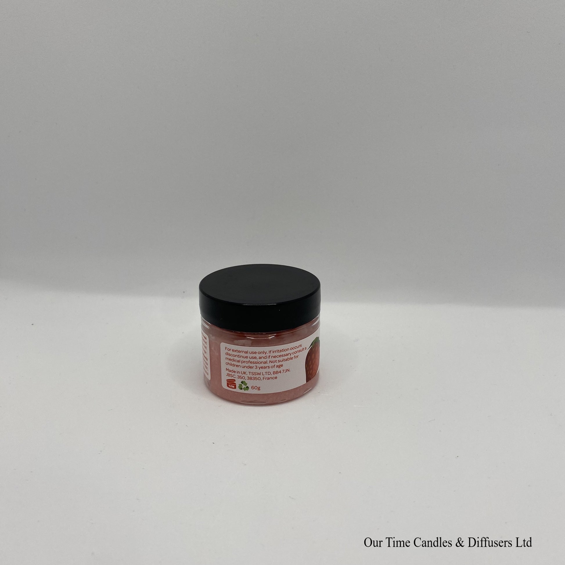 Small clear jar containing lip scrub with black lid