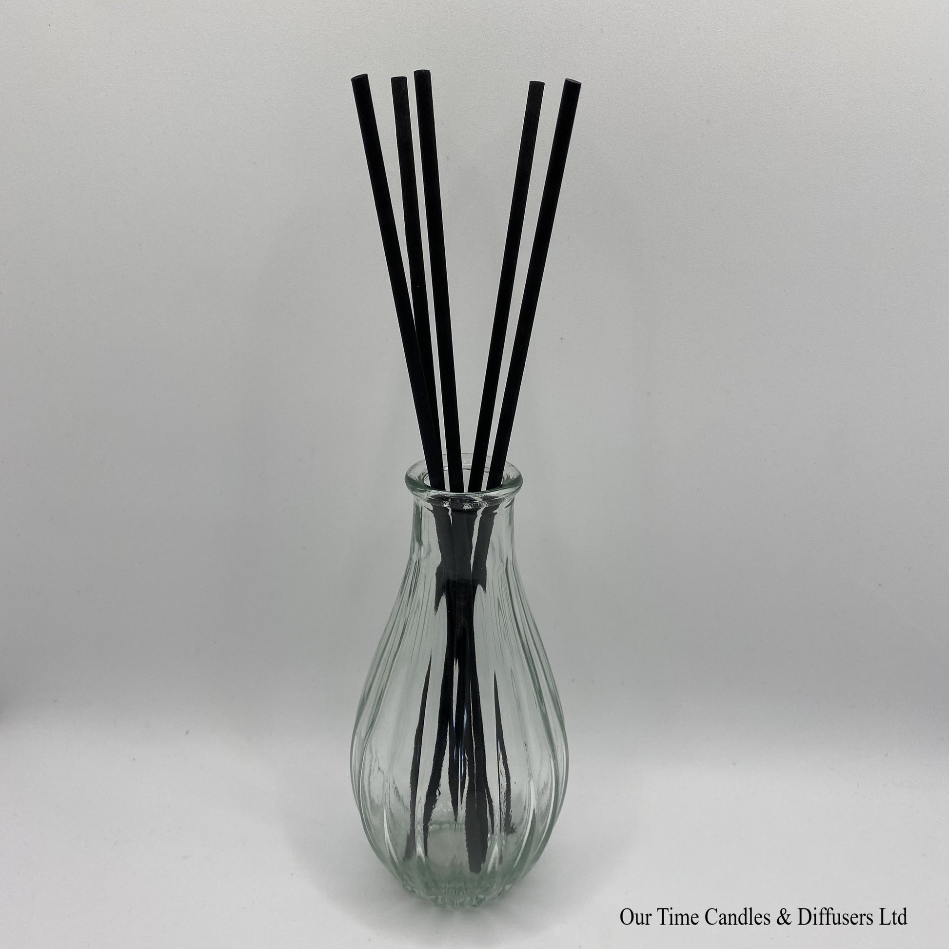 Fluted diffuser vase in clear shown with reeds